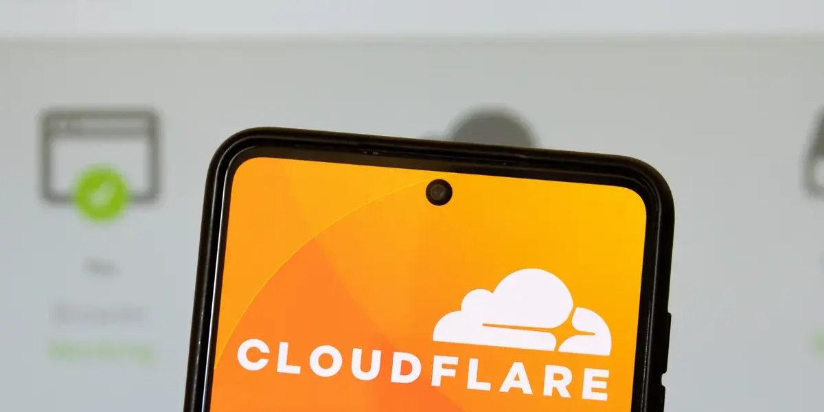 A phone showing the Cloudflare logo in front of a blurred server status page with a green check mark