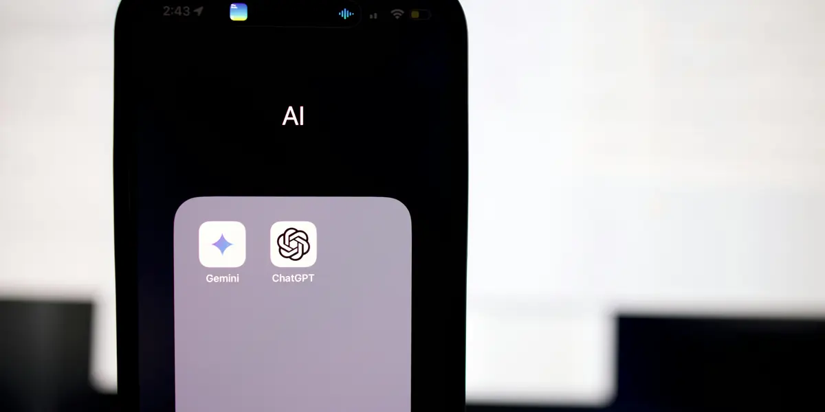 A phone home screen in the dark showing a folder labelled AI, open to reveal two app icons side by side, Gemini with its four-pointed star and ChatGPT with the knot mark, the rest of the screen black